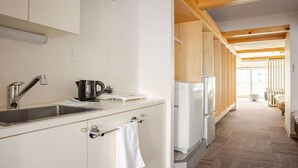 Une cuisine moderne équipée d’un évier, d’une bouilloire et d’un réfrigérateur.