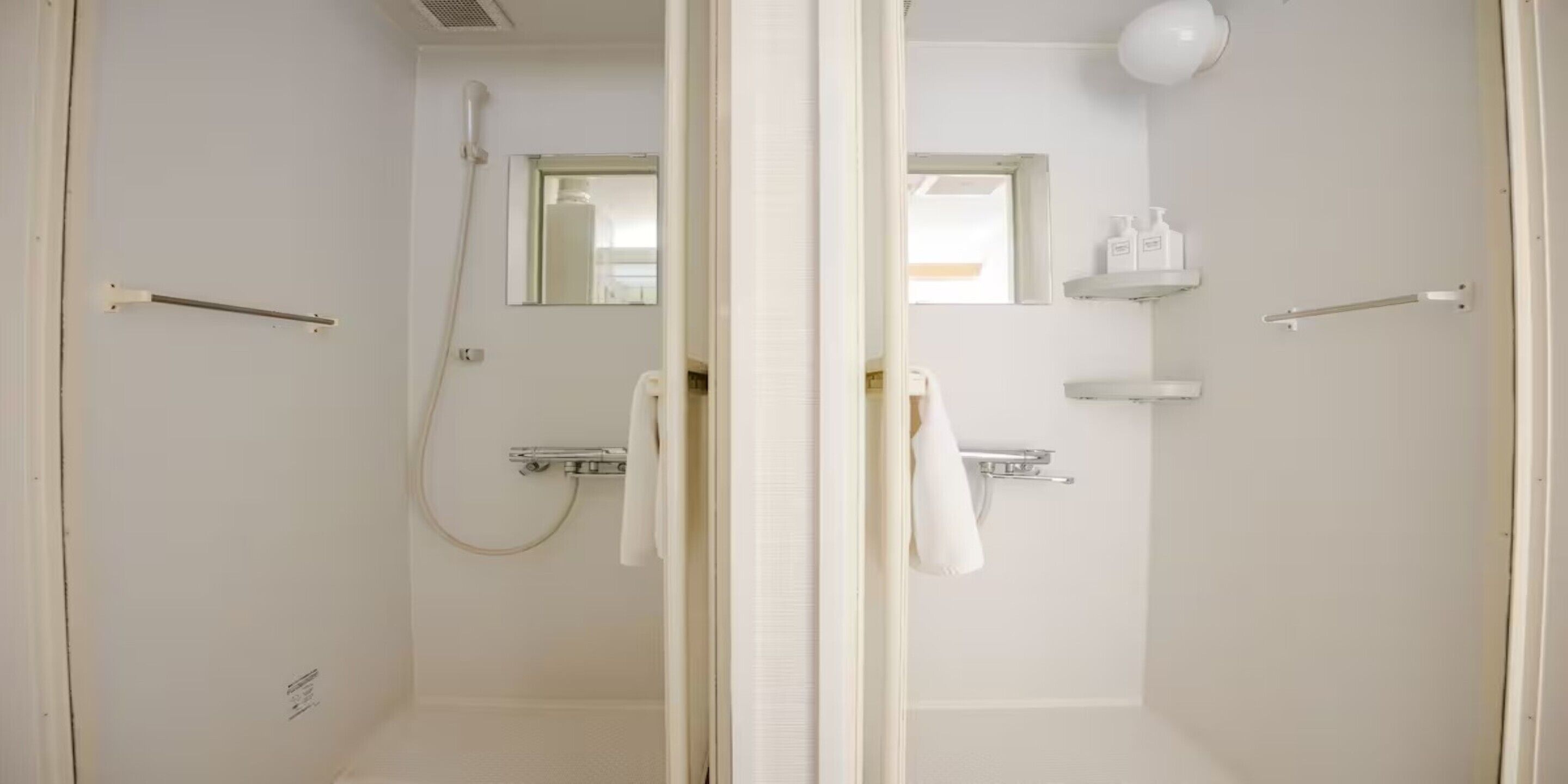 A bathroom with a shower, a toilet, a sink, and a mirror. There are towels hanging on the wall and a shelf with toiletries.
