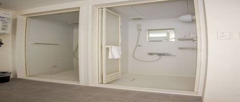 A bathroom with a shower, toilet, and a mirror.