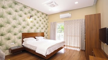 A bedroom with a wooden bed, a nightstand, a TV, and a window with curtains.