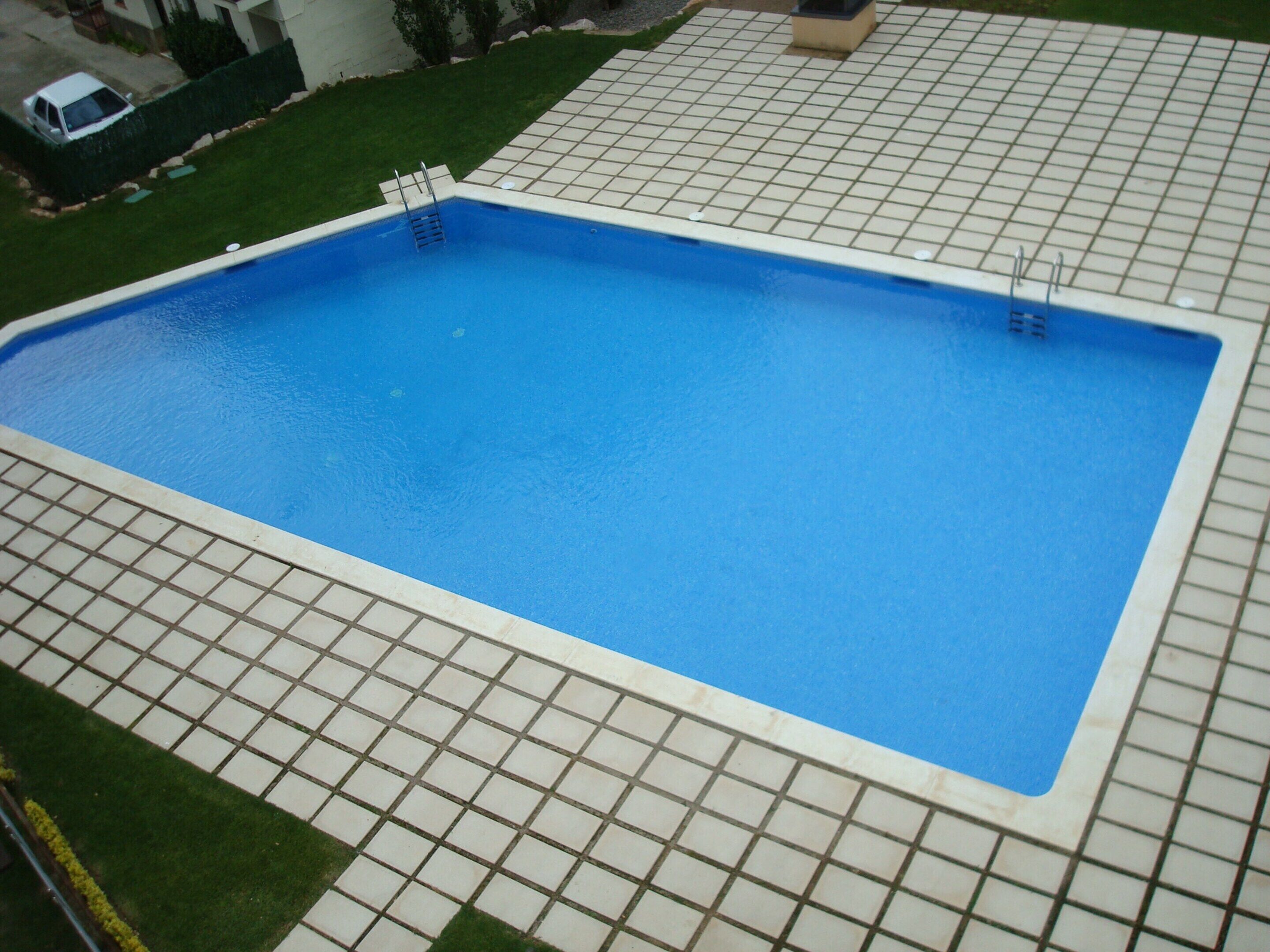 Ein rechteckiger Swimmingpool mit einer gefliesten Umrandung.
