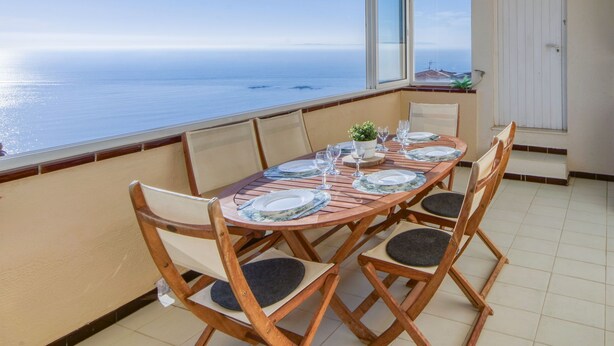 A dining area with a table set for six, overlooking the sea. - Solberg by Interhome (Roses)