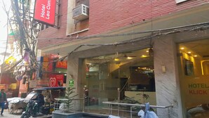 A hotel entrance with a red sign, a glass door, and a visible staircase leading inside. - Hotel Leo Continental  (New Delhi)