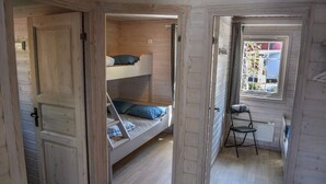 A wooden cabin with a bunk bed, a chair, and a window with a view of a building. - Spacious Holiday Home in Kinsarvik (Ullensvang)