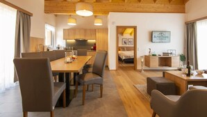 A modern interior with a dining area, kitchen, and a living space. - Penthouse in Wagrain Near Grafenberg Lift (Wagrain)