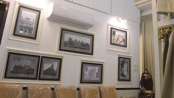 A waiting area with a chandelier, framed pictures on the wall, and a ceiling fan.
