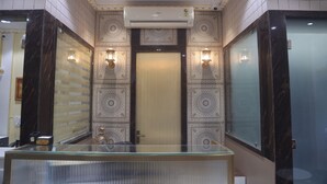 Une salle de bain moderne avec une paroi en verre, des carreaux décorés et un système de climatisation central.