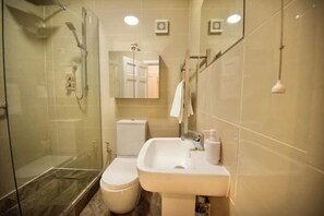 Een douche, handdoeken, zeep, toiletpapier