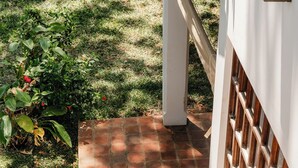 A staircase with terracotta tiles leading to a white door with a wooden lattice design. - Beach front Mawimbi Studio in stunning garden (Coast)