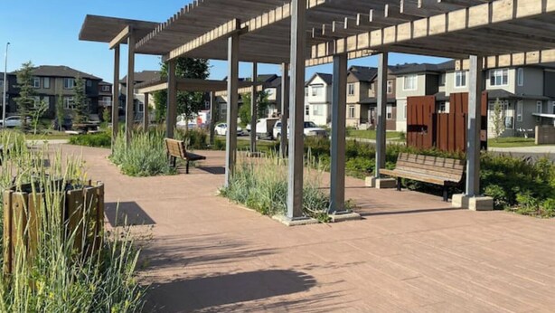A covered outdoor area with benches and a pathway, surrounded by residential buildings. - Charming Oasis Tranquil Suite 8 min Airport, AC (Calgary)