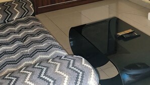 Una stanza con un letto, un armadio e un tavolino.
