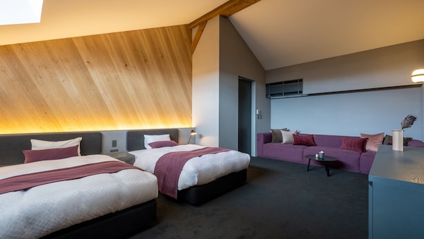 A modern hotel room with two beds, a sofa, and a small table. - NIPPONIA HOTEL Hakodate Port Town (Hakodate)