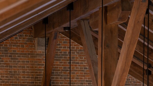 A wooden truss structure with exposed brick walls.