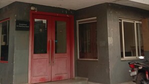 A hotel named "HOTEL NEELKAM" with a red and white facade, a red door, and a motorcycle parked outside. - Hotel Neelkanth Inn (Ahmedabad)