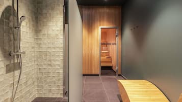 A modern bathroom with a shower, a wooden sauna area, and a wooden bench.