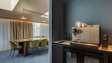 A modern kitchen with a built-in oven, a stainless steel range hood, and a dining area with a table and chairs.