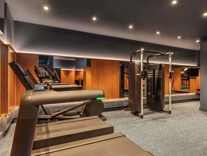A gym with treadmills, a weight machine, and a mirror. - TRIBE Krakow Old Town (Kraków)
