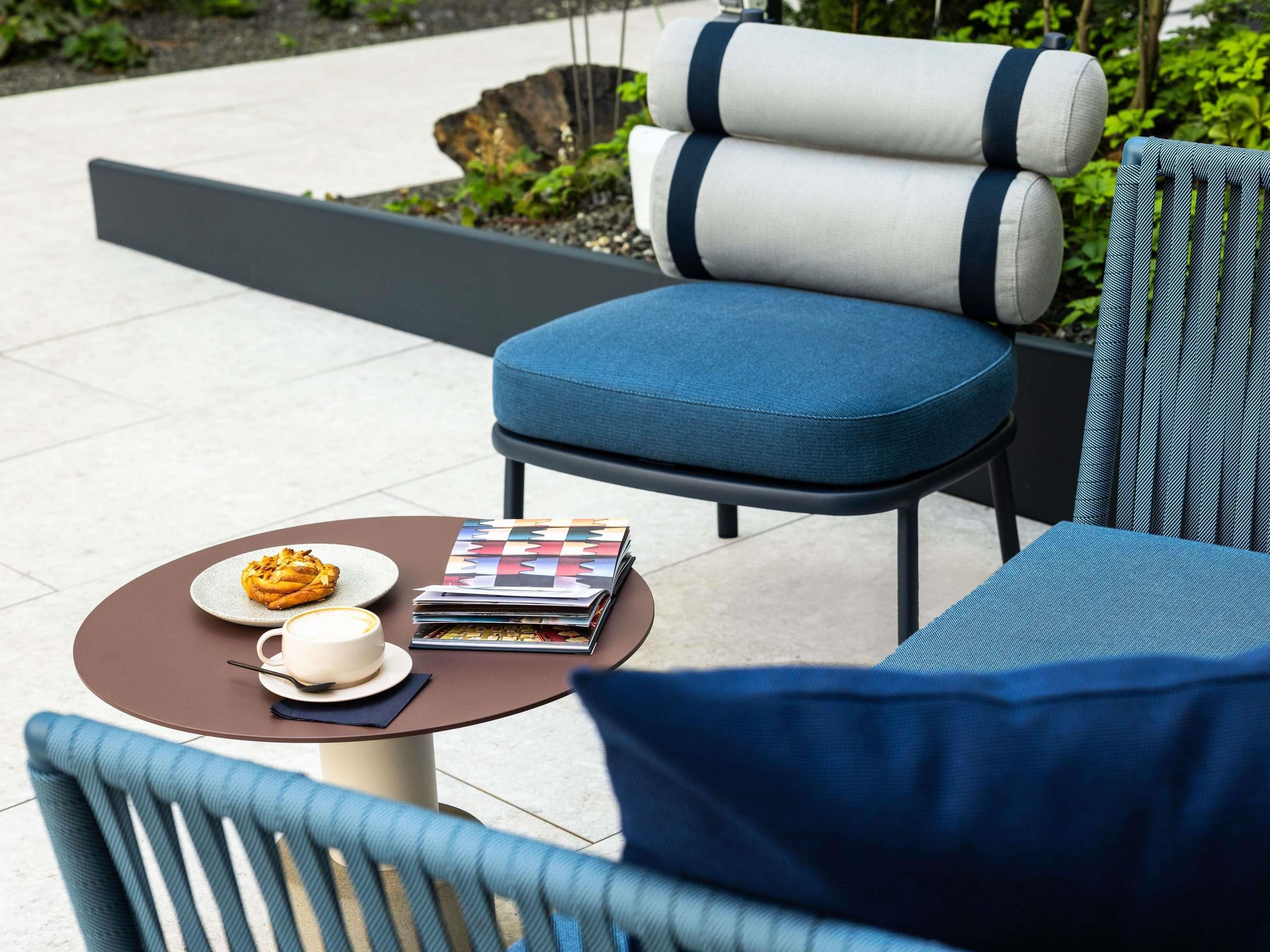 A seating area with a table, a chair, and a sofa.