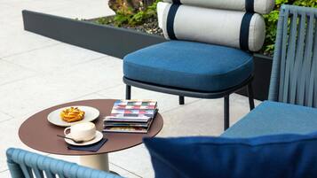 A seating area with a table, a chair, and a sofa.