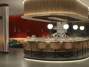 Un área de bar moderna con una barra curva, taburetes y lámparas colgantes.