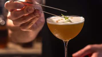 A cocktail in a martini glass with a garnish on top.