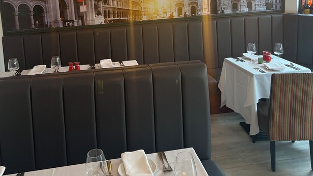 A restaurant with booth seating, tables set for dining, and a large cityscape mural on the wall. - Piccolo Hotel (Glasgow)