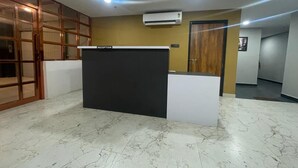 A reception area with a reception desk, a wooden door, and an air conditioning unit on the ceiling. - HOTEL BLACK GRAPES INN (Bhubaneshwar)