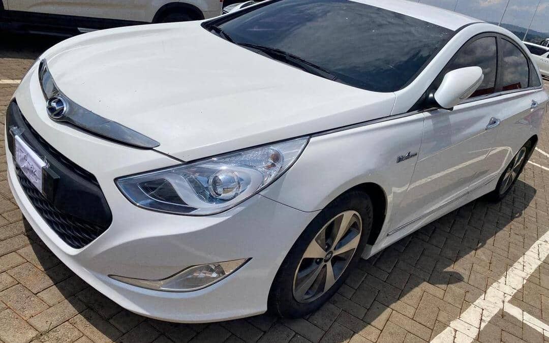 Une berline blanche était garée sur un parking.