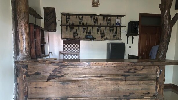 Una encimera de madera rústica con un estampado de cuadros, una mesita pequeña y un estante con tela estampada.