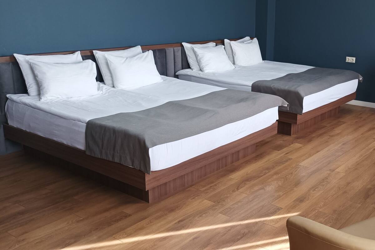 A hotel room with two beds, a desk, and a chair.