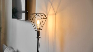 Eine Stehlampe mit geometrischem Design und freiliegender Glühbirne.