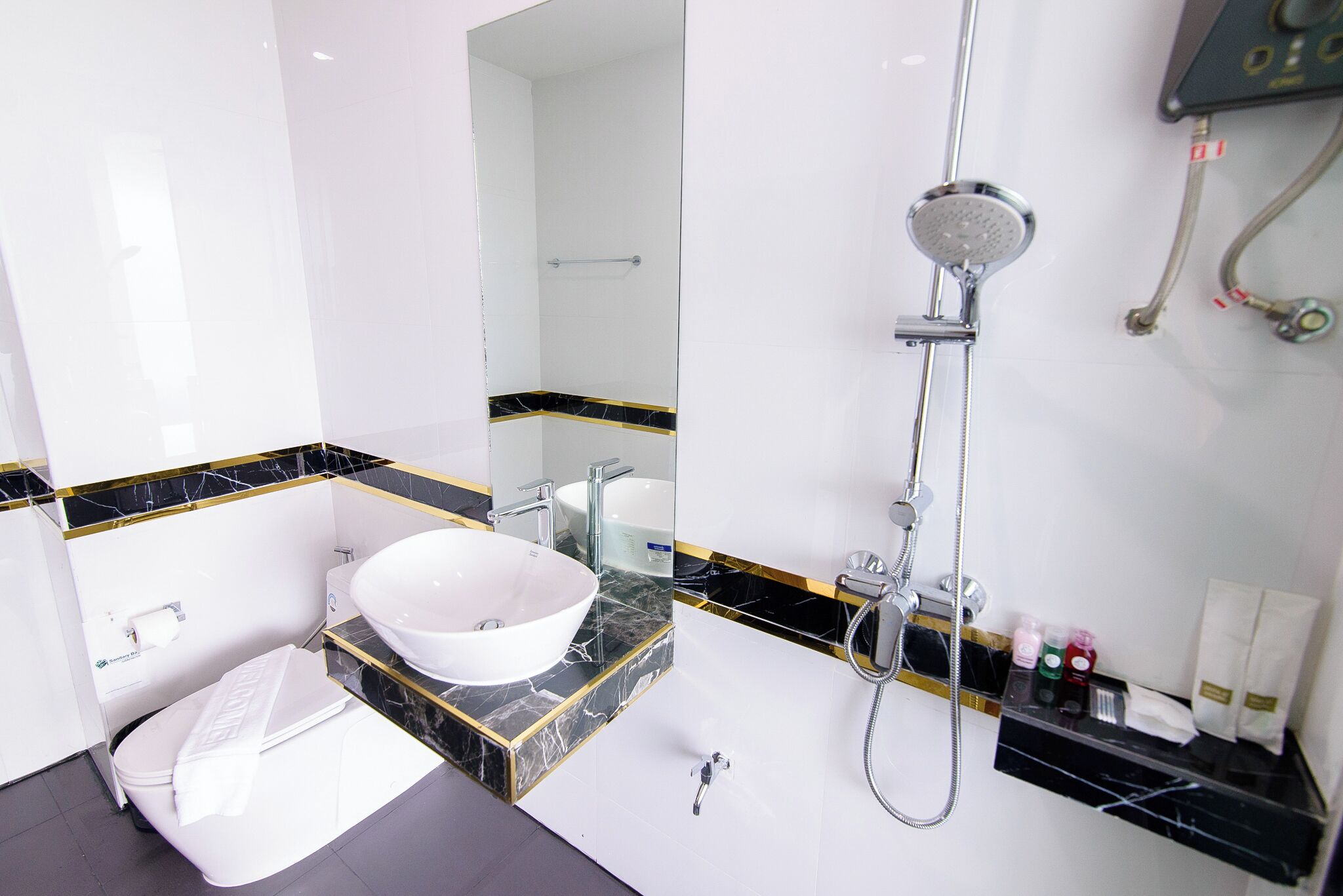A modern bathroom with a white sink, a toilet, and a shower.
