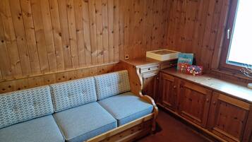 Ein Holzblock-Interieur mit einer Couch, einem kleinen Tisch und einem Fenster.