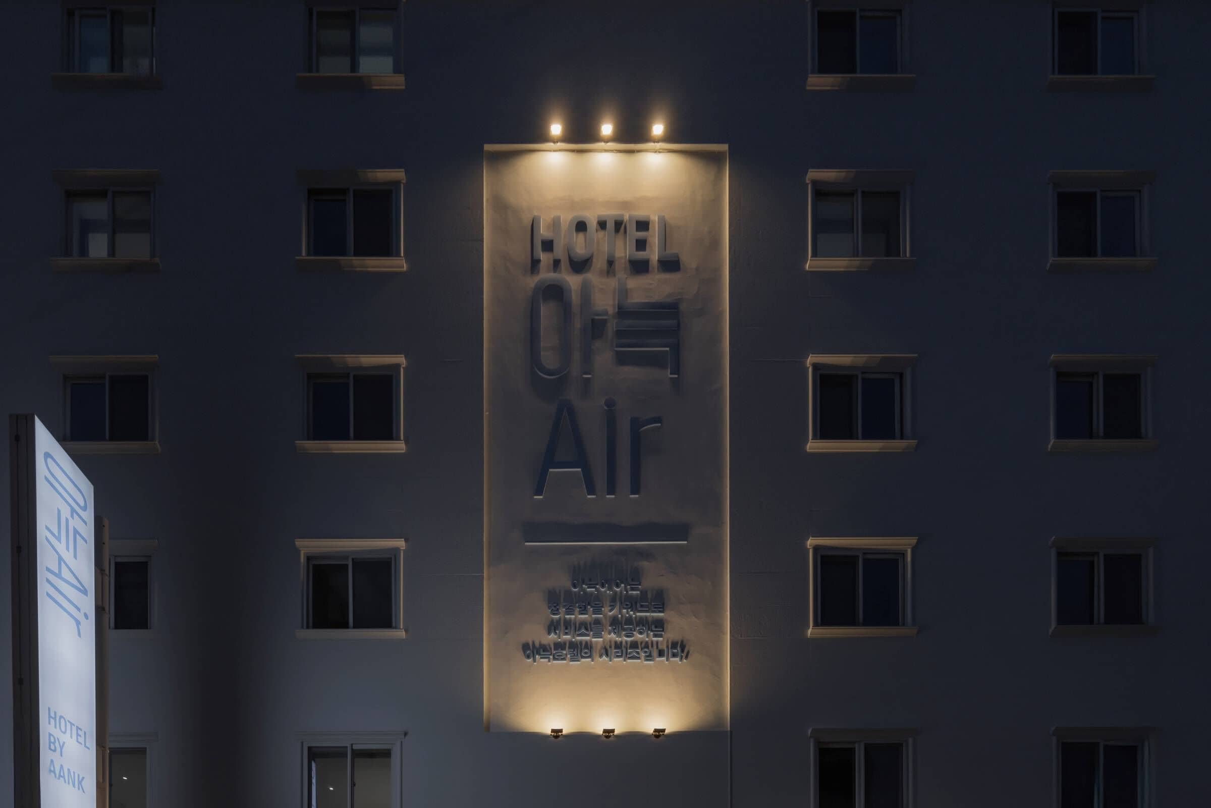 Un letrero de hotel con el nombre "HOTEL AIR" y una pancarta vertical con texto adicional.