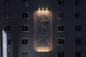 A hotel sign with the name "HOTEL AIR" and a vertical banner below with additional text.