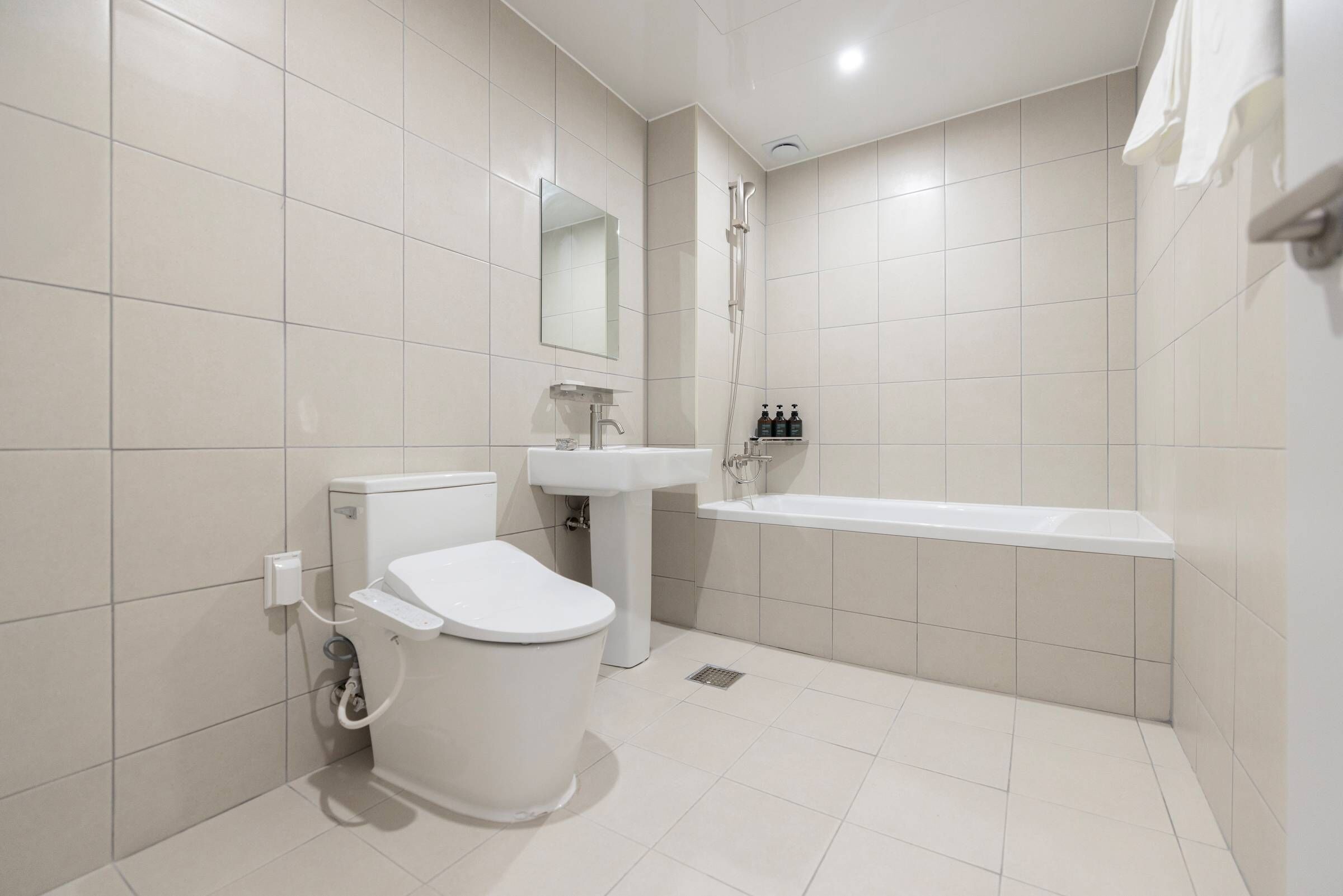 A modern bathroom with a toilet, sink, and bathtub.