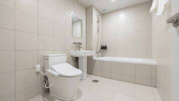 A modern bathroom with a toilet, sink, and bathtub.