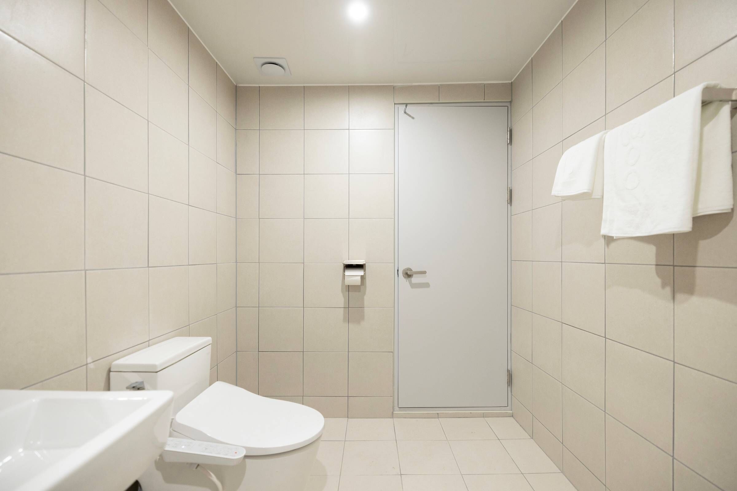 A small, modern bathroom with a toilet, sink, and shower.