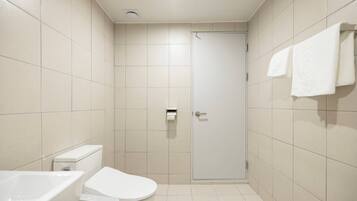 A small, modern bathroom with a toilet, sink, and shower.