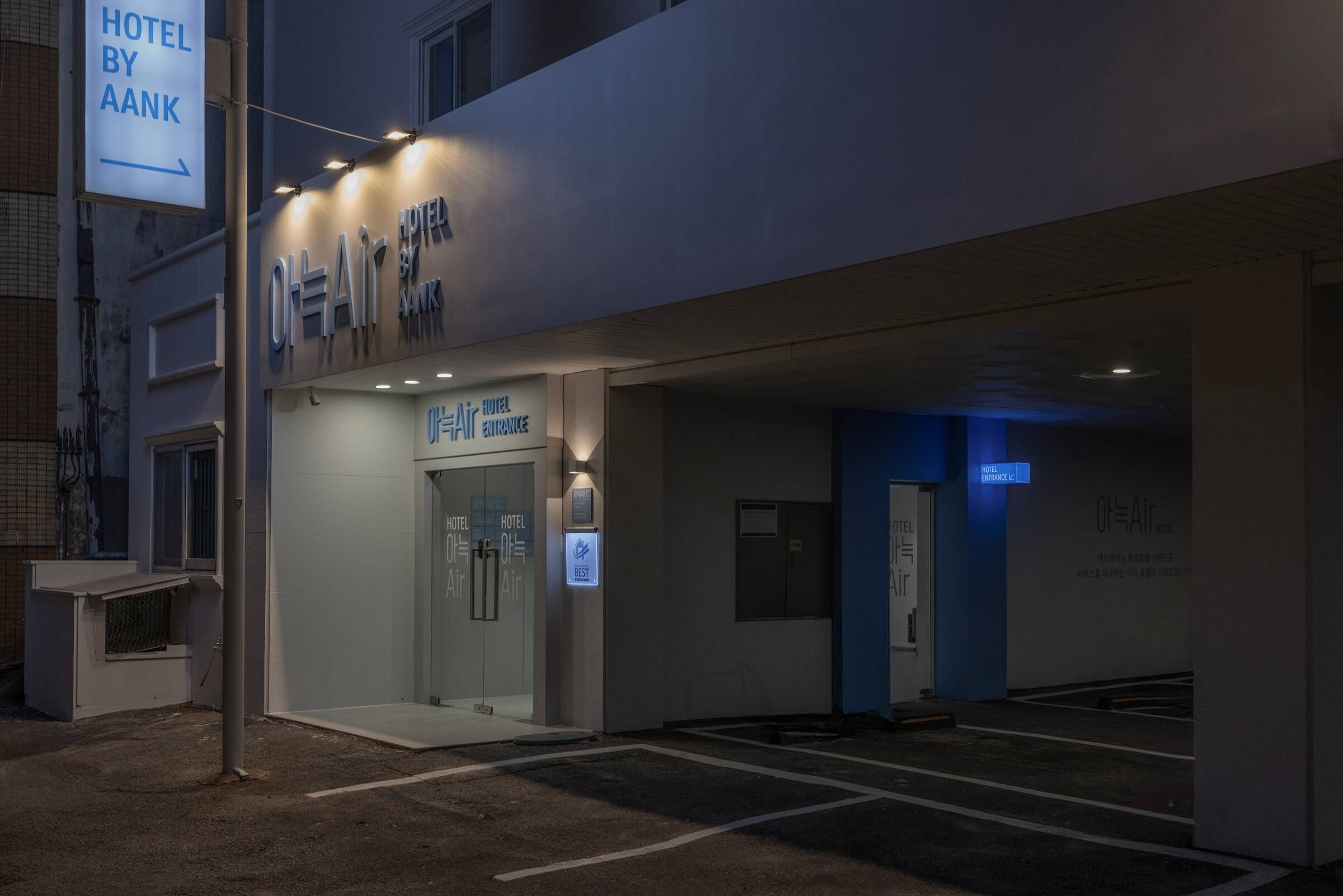Entrada d'un hotel amb un cartell que diu "HOTEL BY AANK" i una porta d'entrada de vidre.