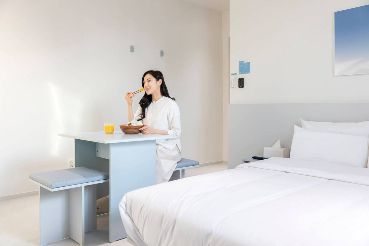 Une chambre d’hôtel avec un lit, un bureau et une chaise.