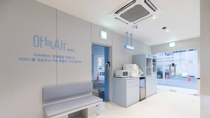 Un hall d’hôtel avec un banc, un four à micro-ondes et un espace en libre-service.