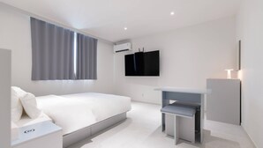 Une chambre à coucher moderne avec un lit, une table de chevet et un bureau avec une chaise.