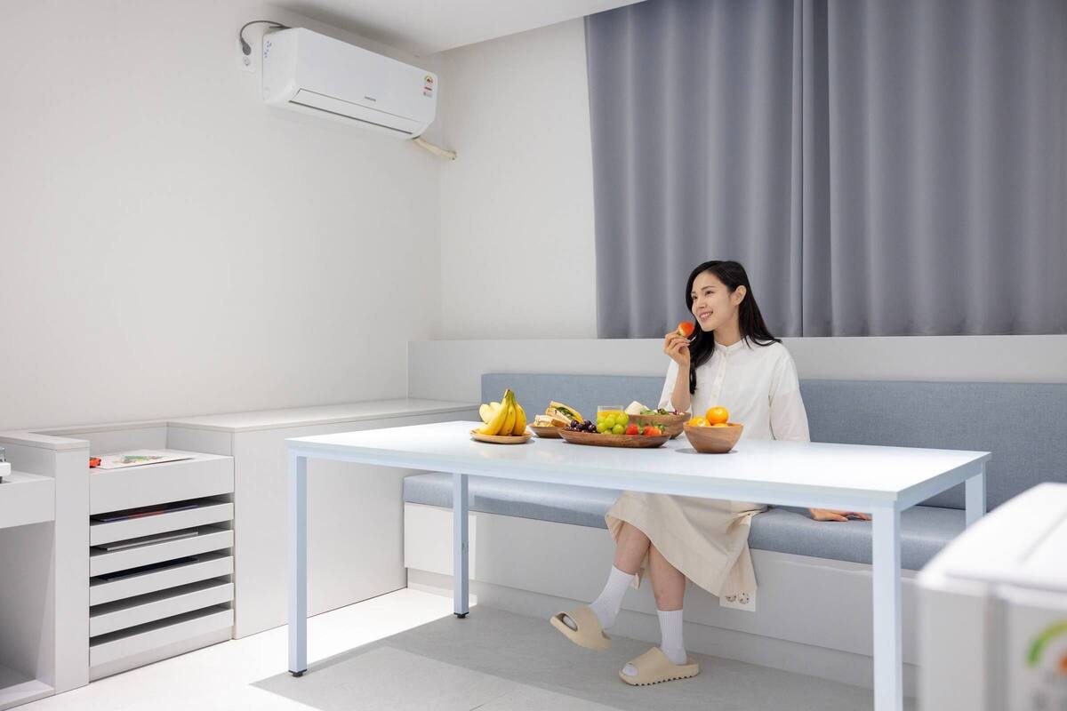 Une pièce moderne et minimaliste, avec une table blanche, un canapé bleu et un meuble blanc.