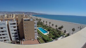 Un immeuble de grande hauteur doté d’une piscine et offrant une vue sur la plage.