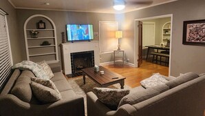 A living room with a fireplace, a television, a sofa, and a coffee table. - Classy and Comfortable Home (San Angelo)