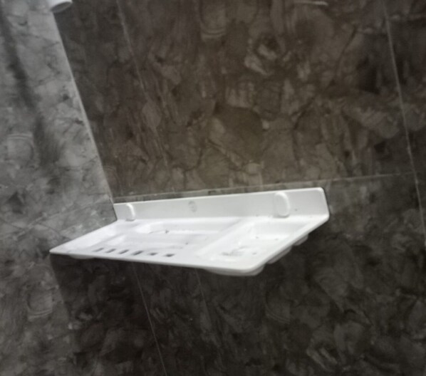 Un bagno con un lavandino bianco e una parete in marmo.