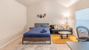 A bedroom with a bed, a sofa, a coffee table, and a chair. - Cozy Vibe in Frisco/Little Elm (Little Elm)