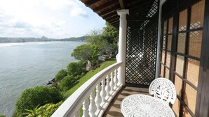 A balcony with a view of the sea, white chairs, and a wooden railing. - Closenberg Hotel  (Galle)