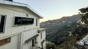 Hotel 'Dev Palace' met een bordje, omgeven door een glooiend landschap.